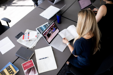 Student studying at desk with laptop