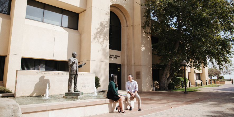 Two students sitting outside Graziadio school entrance in Malibu