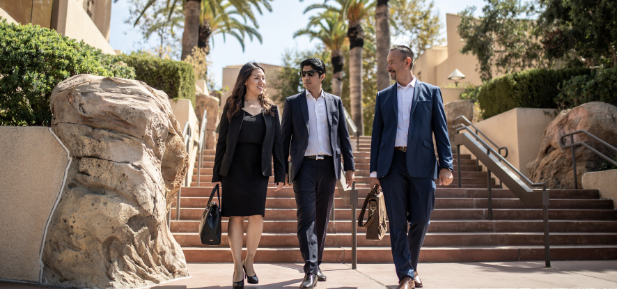 Students and faculty member walking down the stairs outside of the campus building