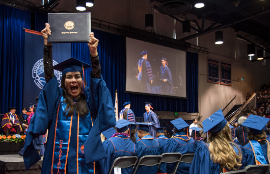 Student holding up her college diploma