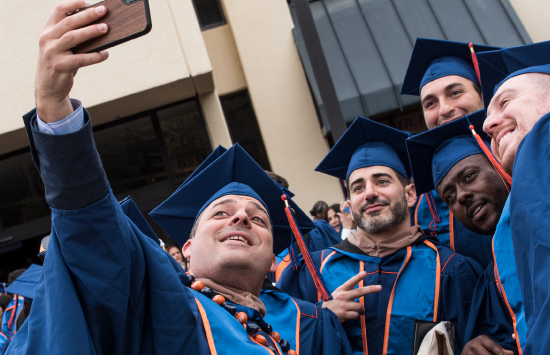 Group of graduating students taking selfie at commencement