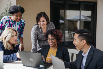 students sitting around a laptop