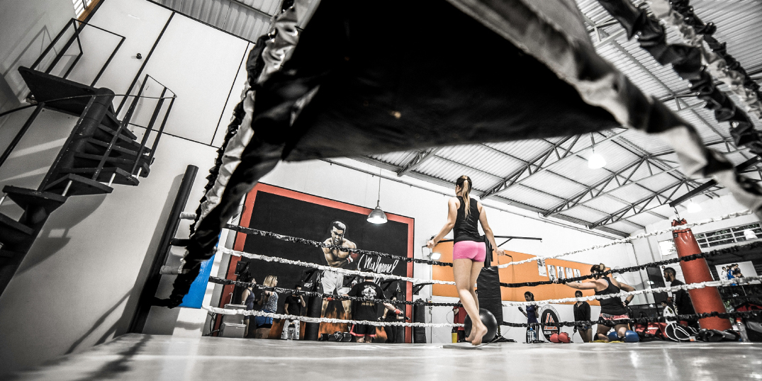 Woman fighter practicing in fighting ring