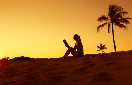 Student reading bible at the beach